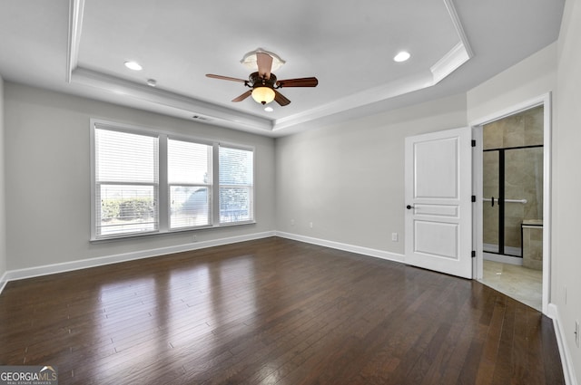 interior space featuring dark wood-type flooring and a tray ceiling