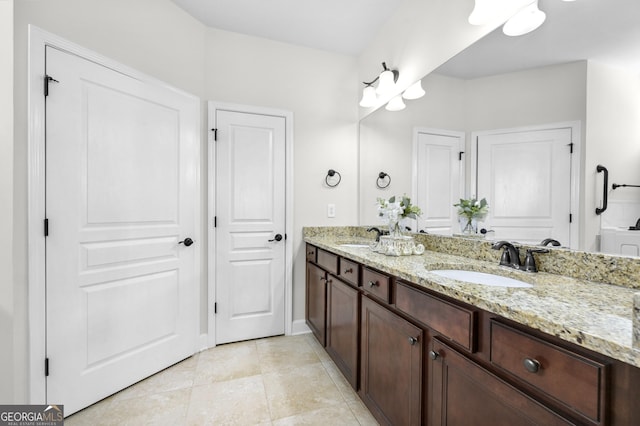 full bathroom featuring double vanity, tile patterned flooring, baseboards, and a sink