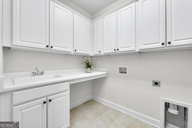 clothes washing area with hookup for an electric dryer, washer hookup, a sink, baseboards, and cabinet space