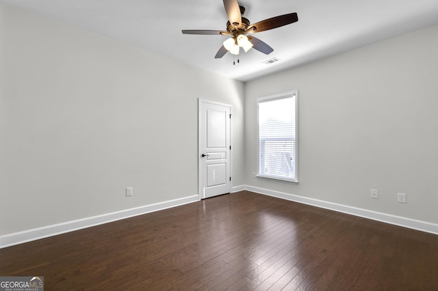 unfurnished room featuring dark wood-style floors, ceiling fan, visible vents, and baseboards