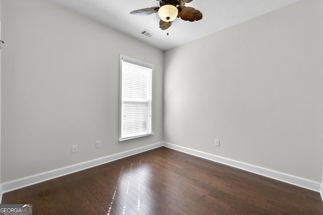 spare room featuring wood-type flooring, visible vents, baseboards, and a ceiling fan