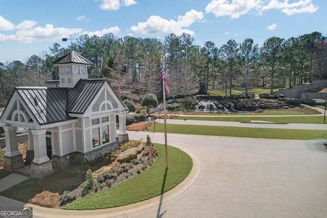 view of property's community featuring decorative driveway and a lawn