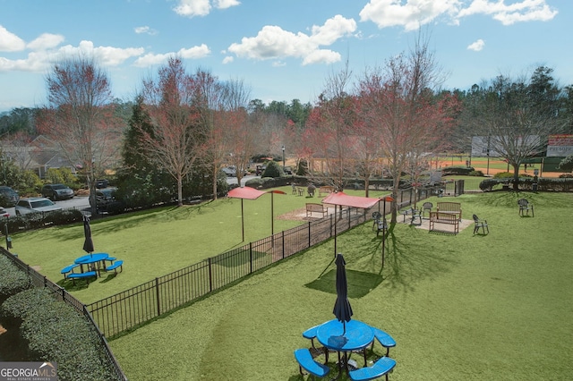 view of community with a yard and fence