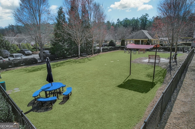 view of property's community featuring a yard and fence