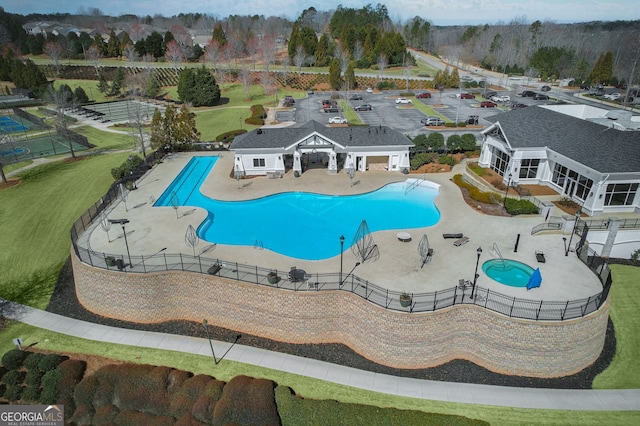 community pool with a patio and fence