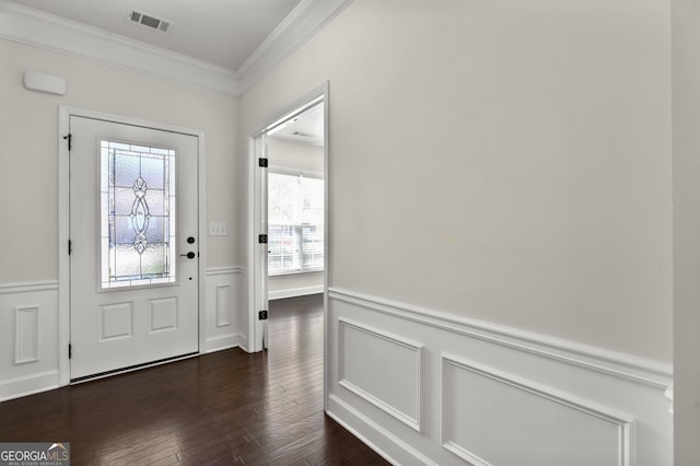 entryway with visible vents, wainscoting, ornamental molding, dark wood-style flooring, and a decorative wall