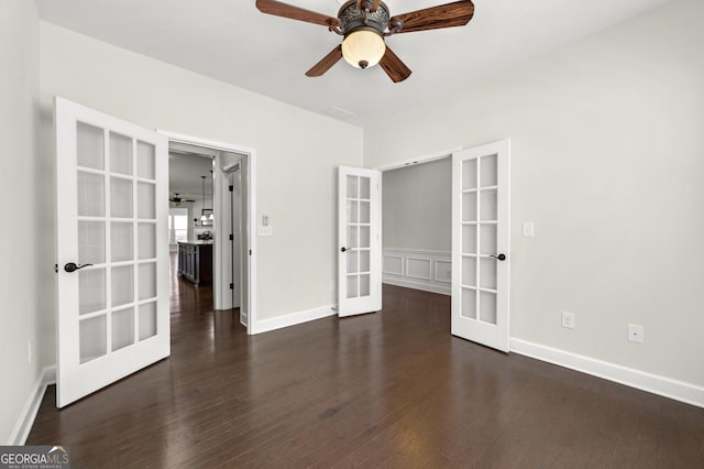 spare room with baseboards, a ceiling fan, wood finished floors, and french doors