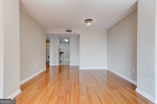 unfurnished room with baseboards, visible vents, and light wood-style floors