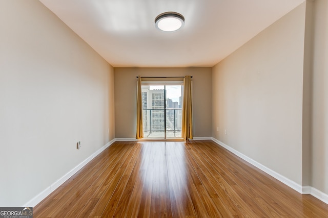 spare room with light wood-style floors and baseboards