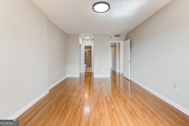 interior space with light wood-style floors, visible vents, and baseboards