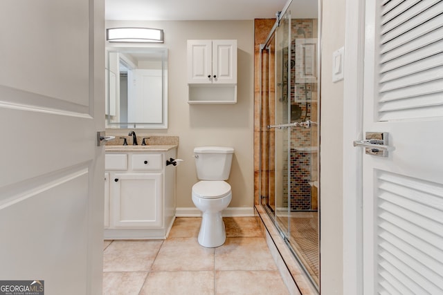 bathroom with a closet, toilet, a stall shower, vanity, and tile patterned flooring