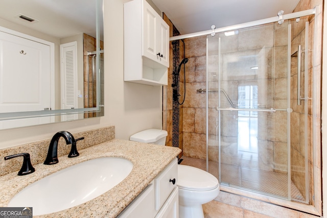 bathroom with toilet, a stall shower, visible vents, and vanity