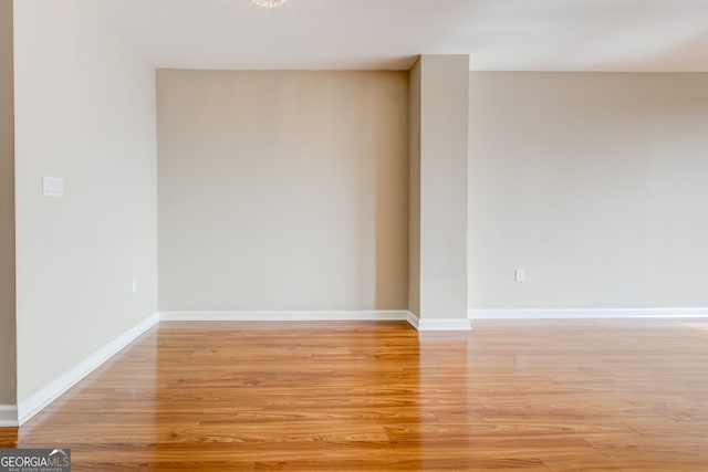 unfurnished room featuring baseboards and light wood finished floors