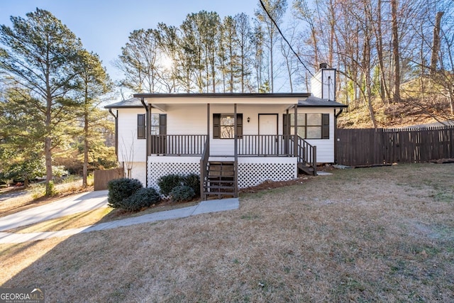 view of front of home featuring stairs, a porch, a chimney, and fence