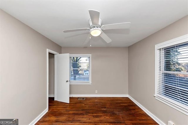 unfurnished bedroom with a ceiling fan, visible vents, baseboards, and dark wood-type flooring