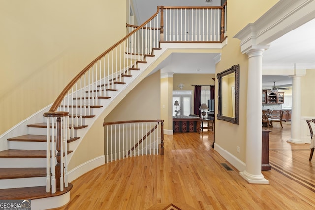 entrance foyer featuring a high ceiling, wood finished floors, and decorative columns