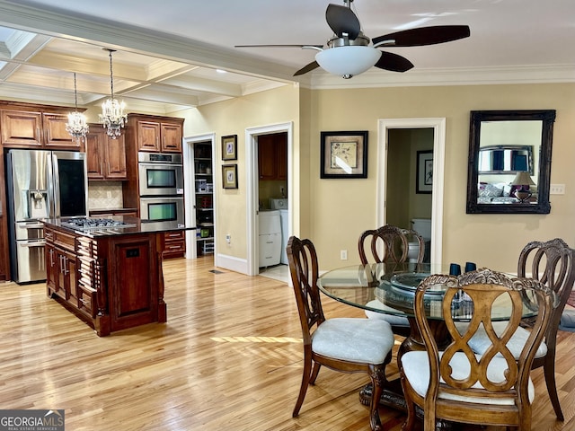 kitchen with dark countertops, light wood-style flooring, a center island, stainless steel appliances, and pendant lighting