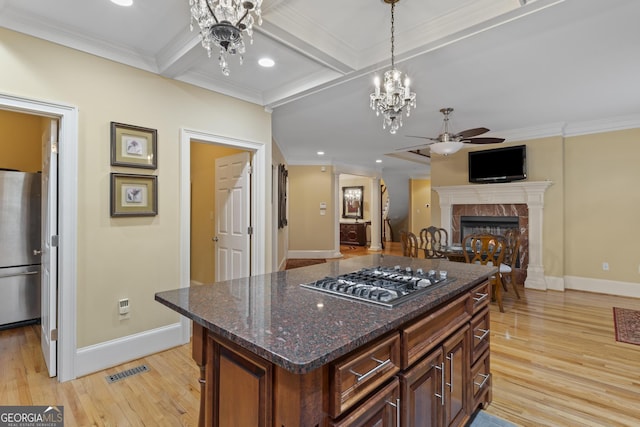 kitchen featuring stainless steel appliances, visible vents, light wood-style floors, and a tiled fireplace