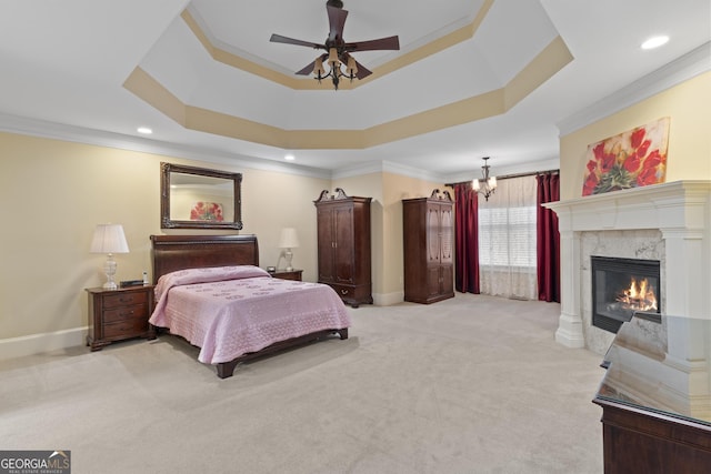 bedroom featuring light carpet, a fireplace, baseboards, a tray ceiling, and crown molding