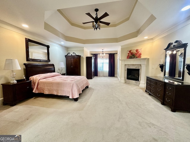 bedroom featuring a raised ceiling, light colored carpet, a premium fireplace, ornamental molding, and recessed lighting