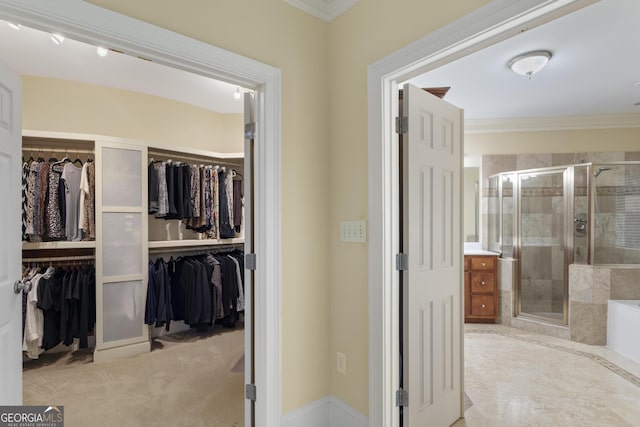 bathroom featuring a stall shower, a washtub, ornamental molding, and a walk in closet