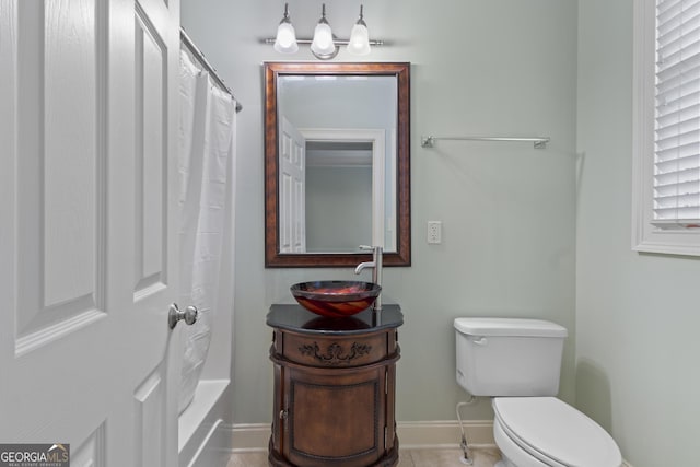 bathroom with toilet, baseboards, shower / bath combo with shower curtain, and vanity