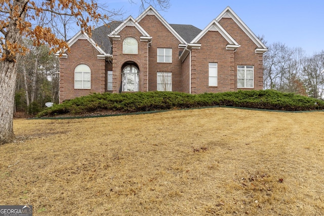 view of front of house featuring brick siding and a front yard