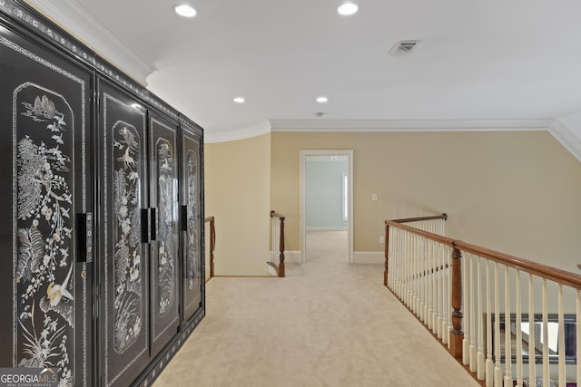 hallway with recessed lighting, light colored carpet, crown molding, and an upstairs landing