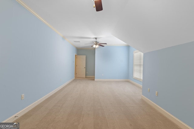 interior space with a ceiling fan, light carpet, and baseboards