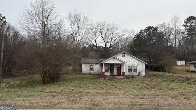 bungalow-style home featuring a porch and a front yard