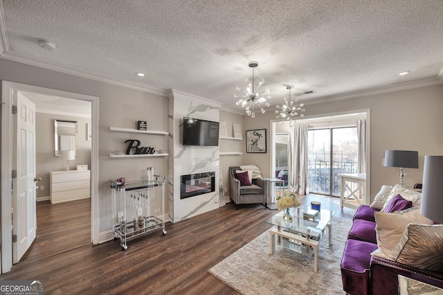 living room with dark wood-style floors, a high end fireplace, crown molding, and a notable chandelier