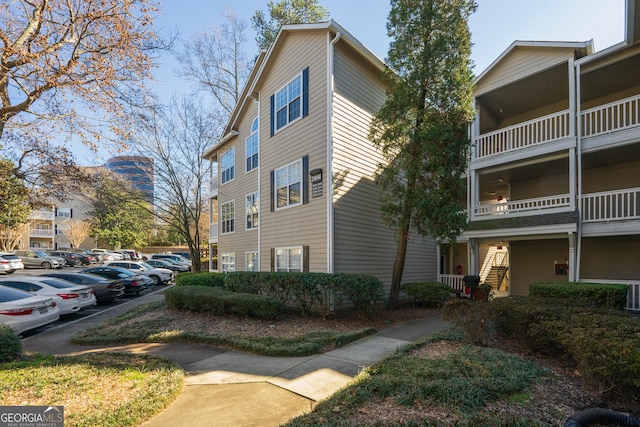 view of property exterior with uncovered parking