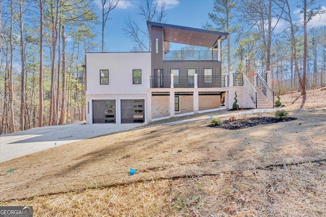 view of front of house featuring stairs, concrete driveway, and an attached garage