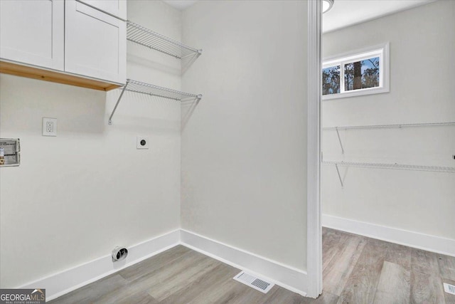 laundry room with cabinet space, baseboards, visible vents, and hookup for an electric dryer