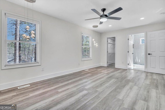 unfurnished bedroom with baseboards, visible vents, a spacious closet, light wood-type flooring, and recessed lighting