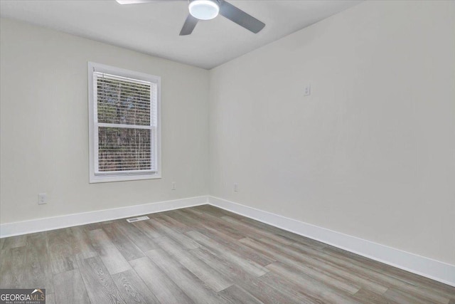 empty room featuring light wood-style floors, visible vents, ceiling fan, and baseboards