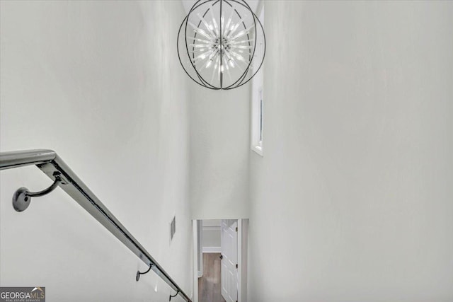 staircase with visible vents and a notable chandelier