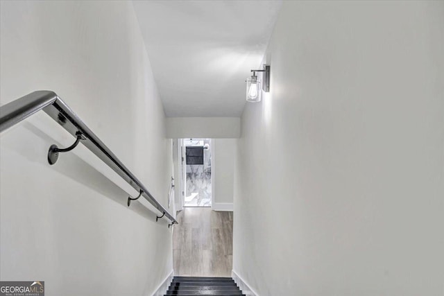 staircase with baseboards and wood finished floors