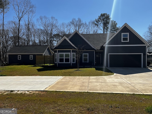 view of front of property featuring a garage, concrete driveway, board and batten siding, and a front yard