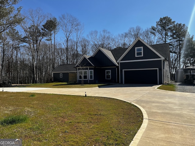 view of front of property featuring a garage, driveway, and a front lawn