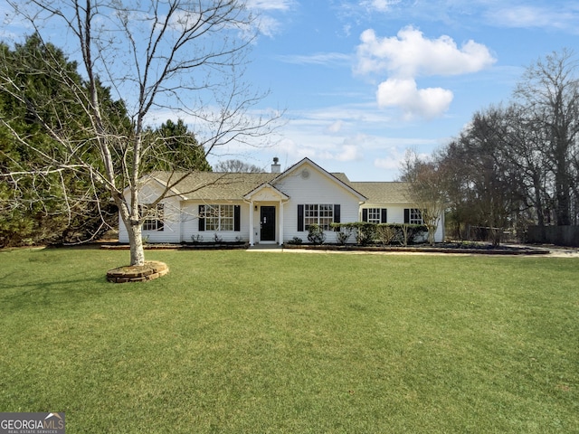 ranch-style house featuring a front yard and a chimney