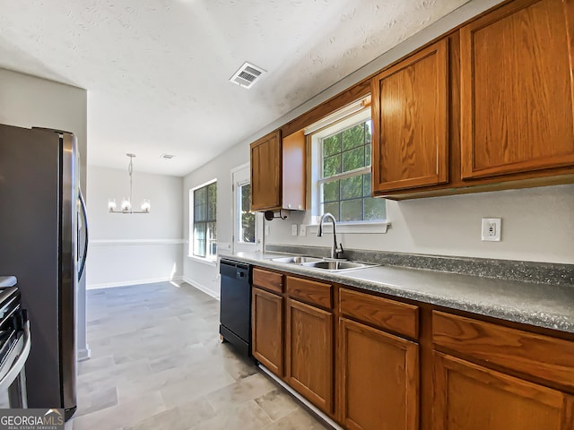 kitchen featuring a sink, visible vents, appliances with stainless steel finishes, dark countertops, and pendant lighting