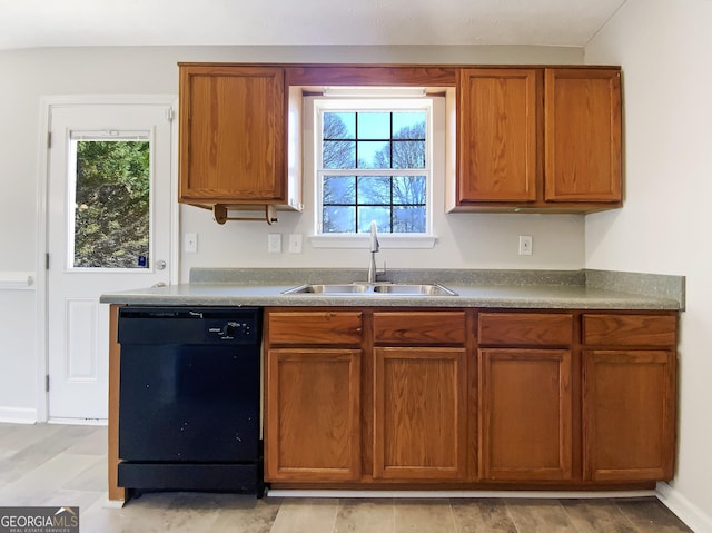 kitchen with brown cabinetry, baseboards, dishwasher, and a sink