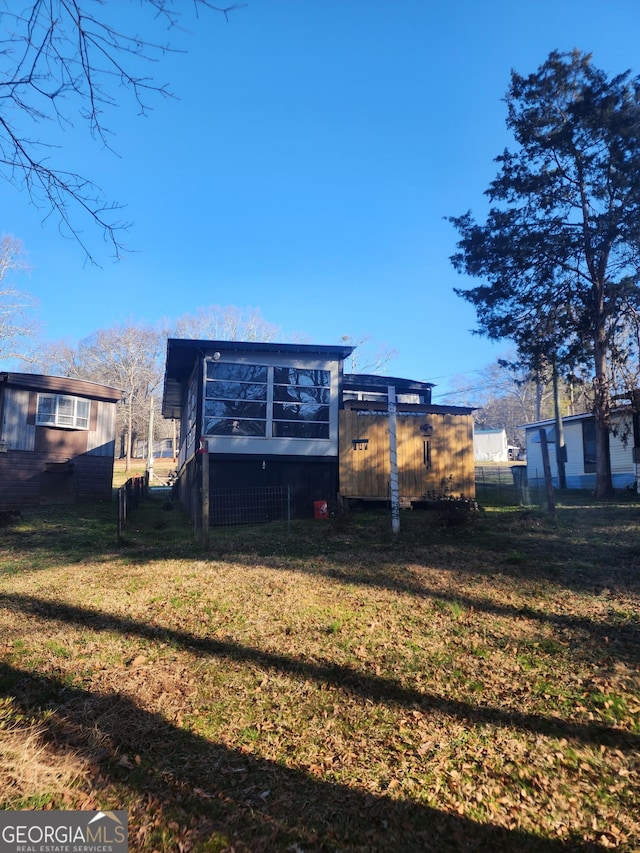 rear view of property with a yard and fence