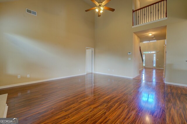 1186 Diamond Xing, Mcdonough, GA 30252 - empty room with a high ceiling, wood finished floors, a ceiling fan, and baseboards
