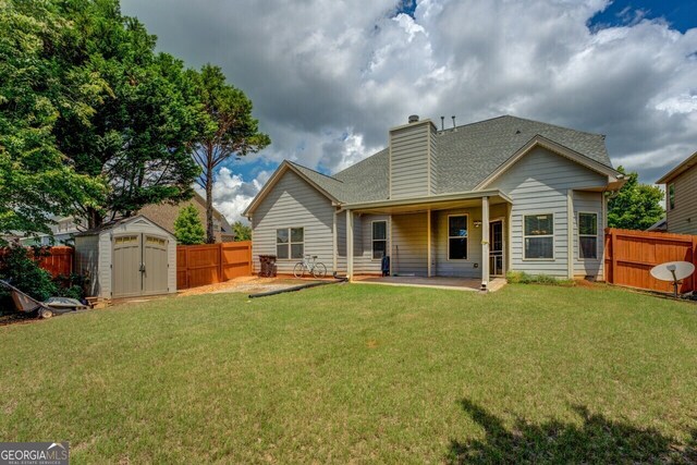 1186 Diamond Xing, Mcdonough, GA 30252 - rear view of property with a storage shed, a patio, a chimney, an outbuilding, and roof with shingles