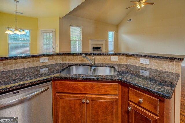 1186 Diamond Xing, Mcdonough, GA 30252 - kitchen featuring dishwasher, a sink, a fireplace, ceiling fan, and dark stone countertops