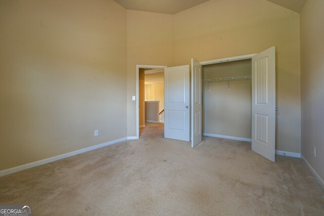1186 Diamond Xing, Mcdonough, GA 30252 - unfurnished bedroom featuring carpet, high vaulted ceiling, baseboards, and a closet
