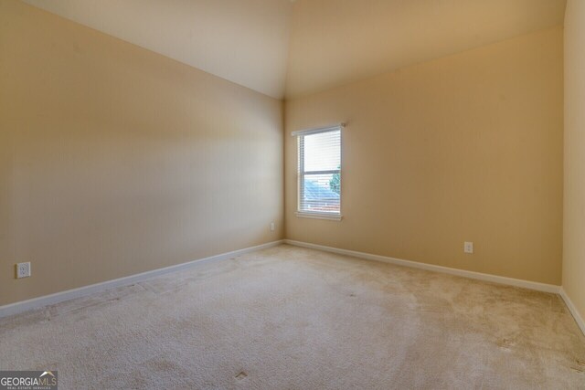 1186 Diamond Xing, Mcdonough, GA 30252 - carpeted spare room featuring lofted ceiling and baseboards