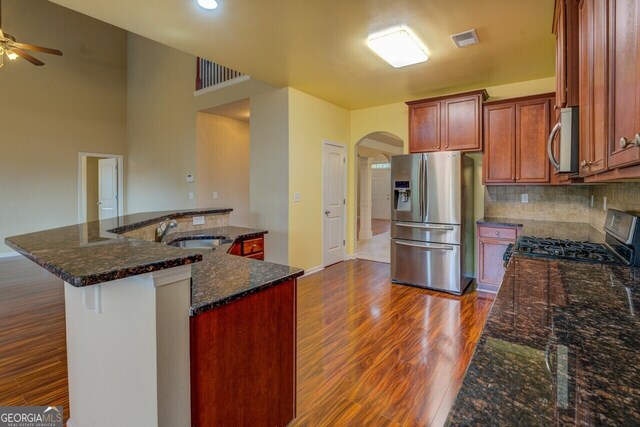 1186 Diamond Xing, Mcdonough, GA 30252 - kitchen featuring appliances with stainless steel finishes, a sink, arched walkways, ceiling fan, and dark wood finished floors